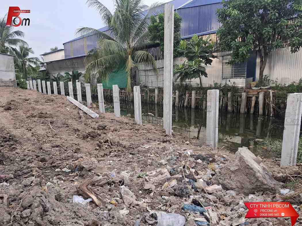 Xe cuốc thi công gạt bùn và ép cột chữ H làm kè chắn sạt lở bờ ao bằng cơ giới
