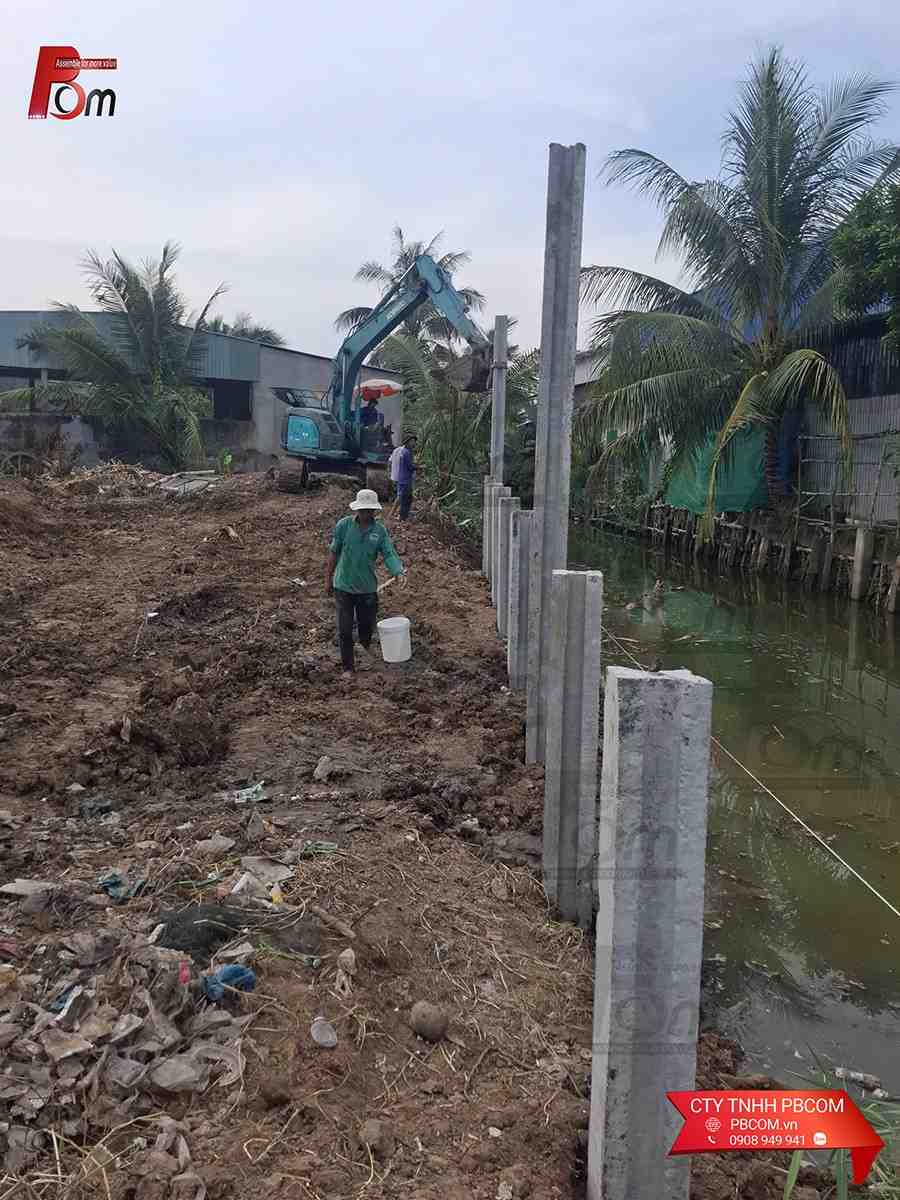 Xe cuốc thi công gạt bùn và ép cột chữ H làm kè chắn sạt lở bờ ao bằng cơ giới